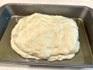 focaccia dough shaped in the pan to rest